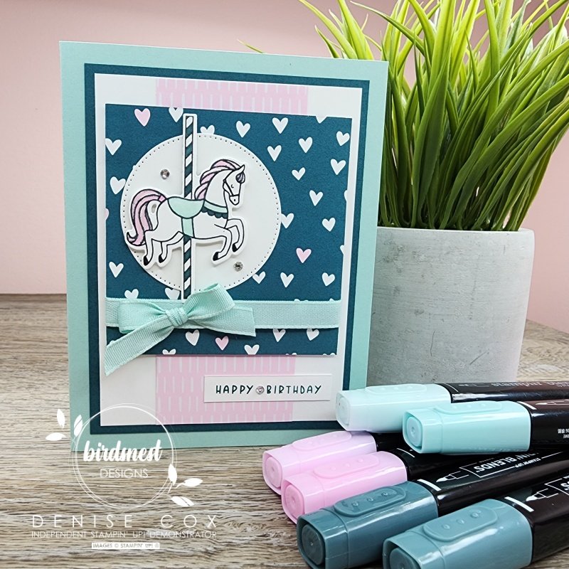 Photo showing the Stampin' Up! Carousel Horses card standing up by a plant and the Stampin' Blends used to colour the card i the front