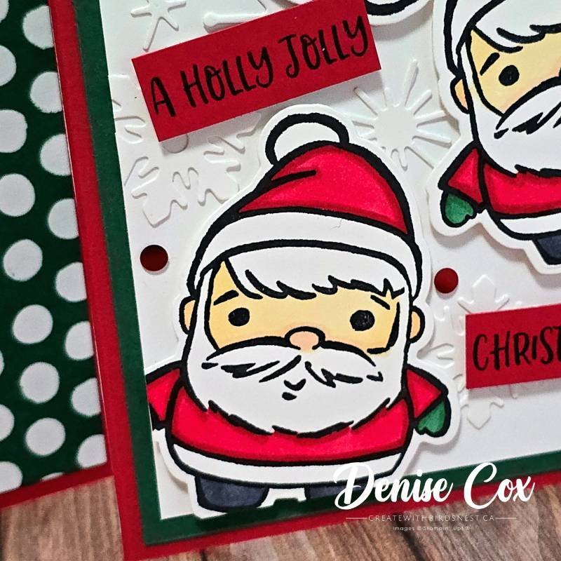 Close-up of Festive Friends Santa image showing colouring details, snowflake embossing and red sentiment strip reading A Holly Jolly.