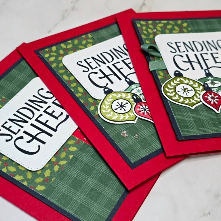 Christmas card with stamped ornaments, embossed patterned paper, green ribbon and rhinestones.